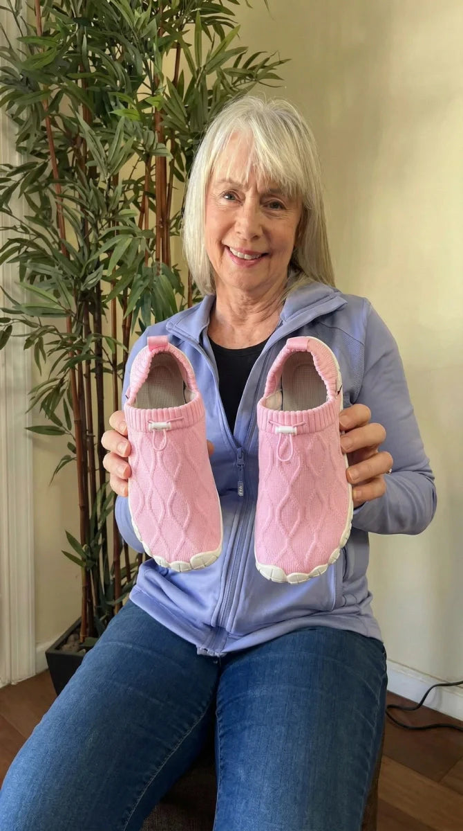 Happy Grace & Ease customer at home holding her new pink pair